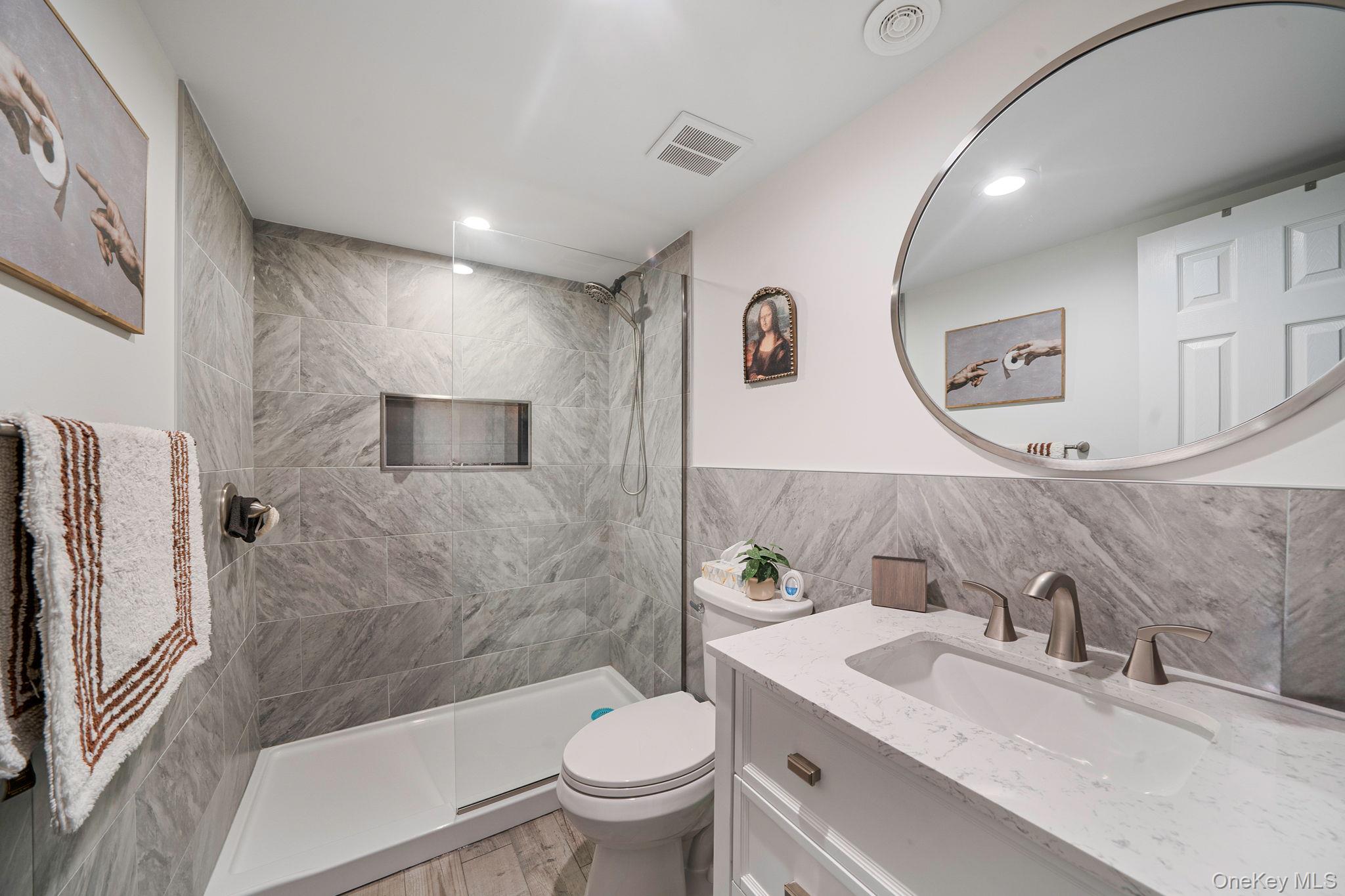 1407 Middle Road, Unit 258 Calverton, NY 11933 - Photo 42 of 50 a bathroom with a sink toilet and shower