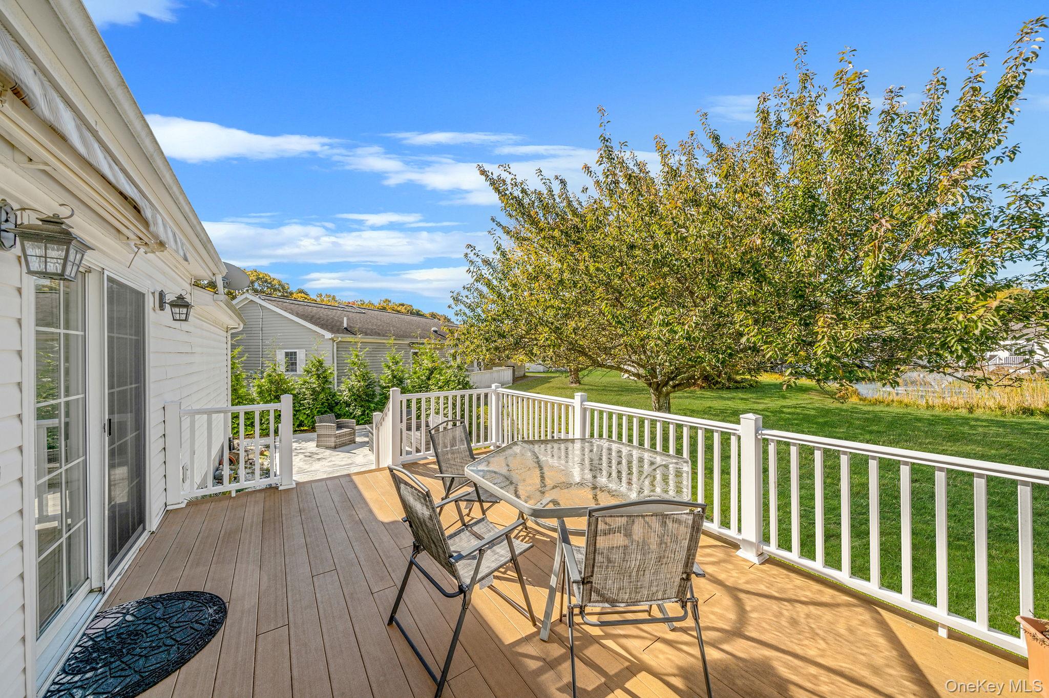 1407 Middle Road, Unit 258 Calverton, NY 11933 - Photo 5 of 50 a view of a chairs and table on the deck
