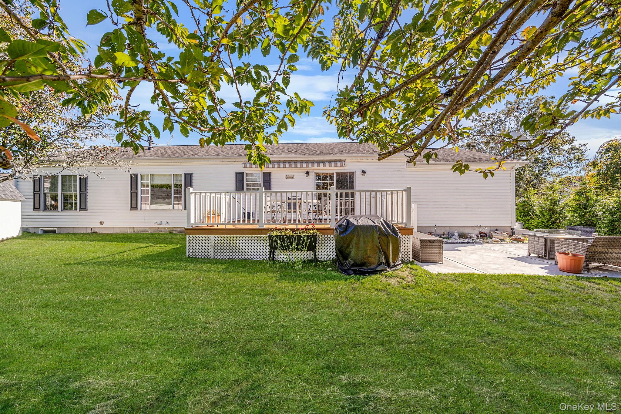 1407 Middle Road, Unit 258 Calverton, NY 11933 - Photo 9 of 50 a view of a house with a patio and a yard