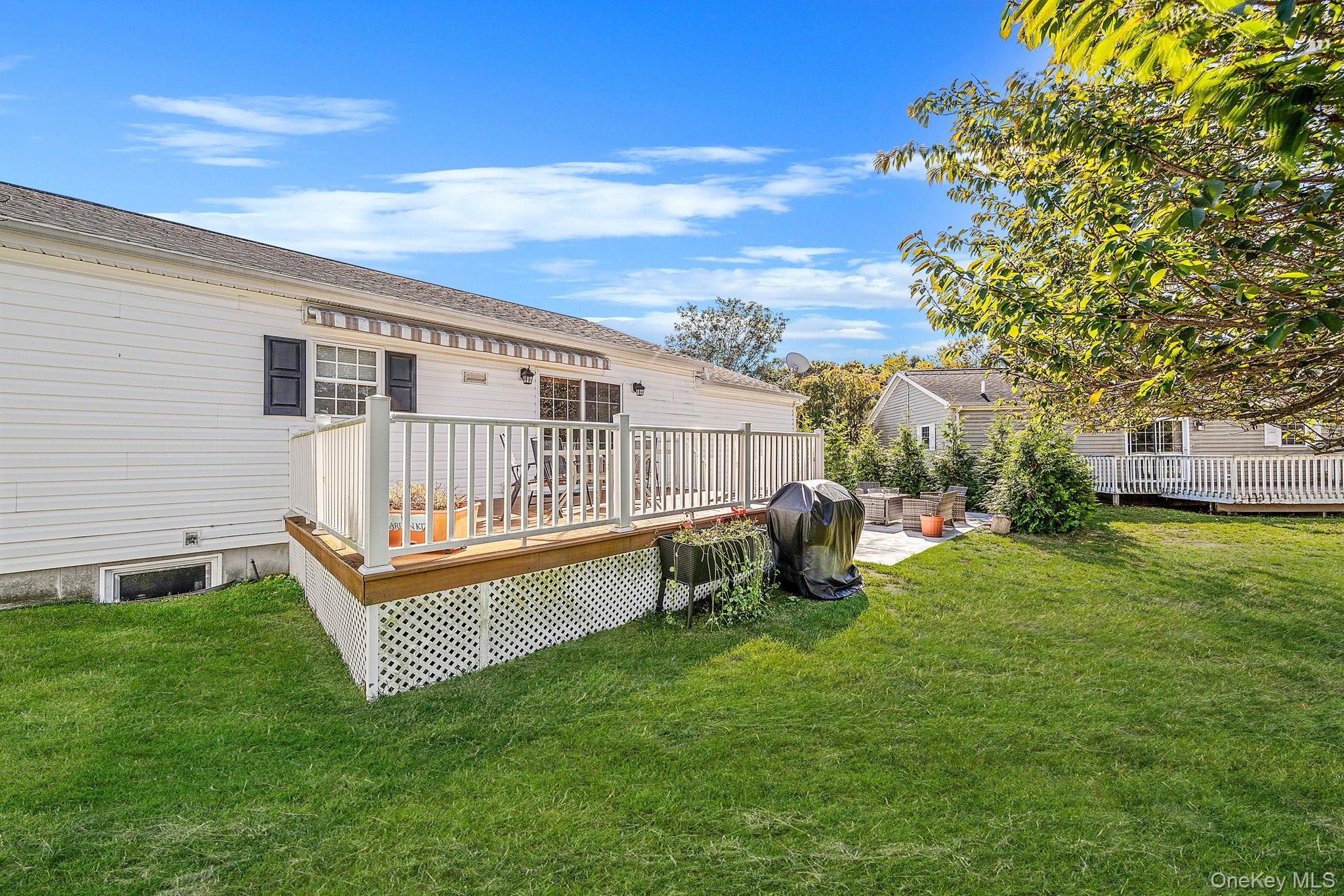 1407 Middle Road, Unit 258 Calverton, NY 11933 - Photo 10 of 50 a view of a chair and table in the backyard