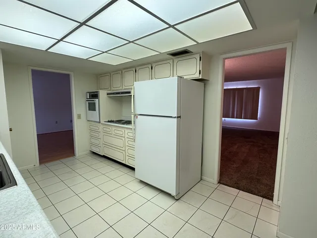 a kitchen with a refrigerator a stove top oven and cabinets
