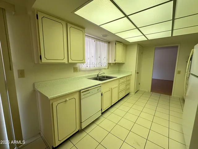 an empty room with wooden floor and windows with curtains