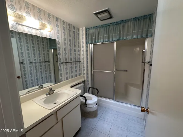 a bathroom with a sink a toilet and shower