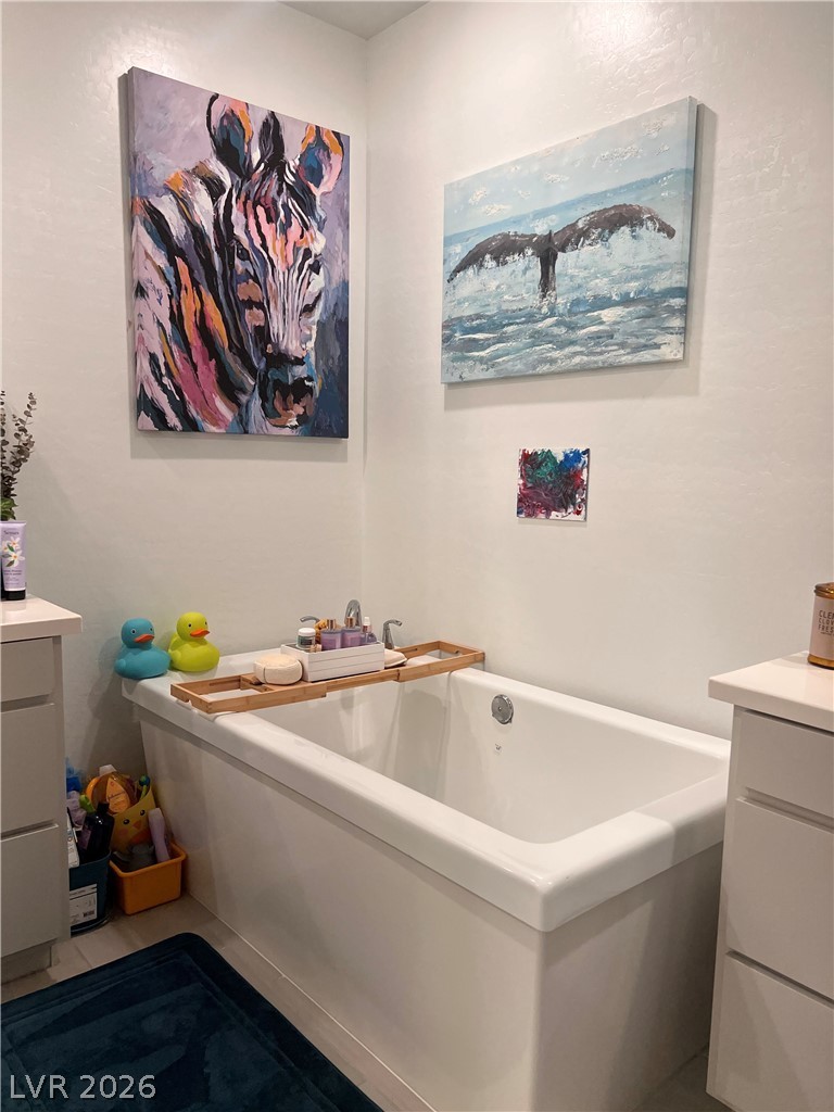 2555 Hampton Road, Unit 2207 Henderson, NV 89052 - Photo 27 of 34 A deep soaking tub offers a serene escape, flanked by practical vanity cabinets for convenience.