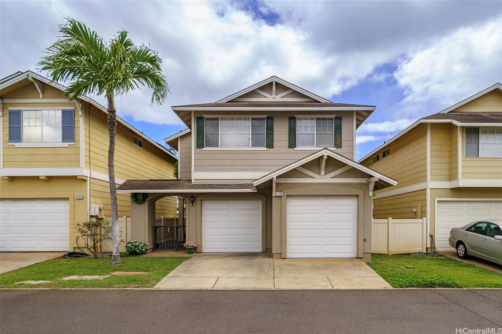 a front view of a house with a garden and palm trees