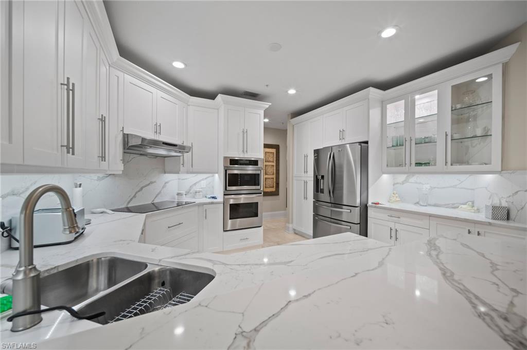 261 Colonade Circle, Unit 2701 Naples, FL 34103 - Photo 11 of 49 a kitchen with granite countertop a sink stainless steel appliances and cabinets
