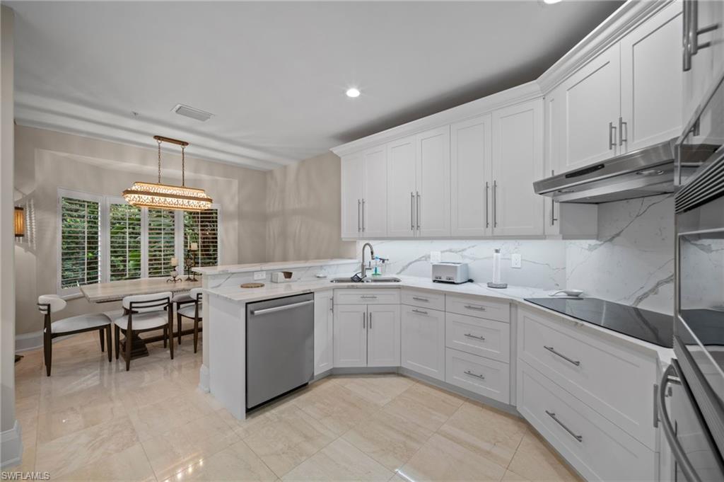 261 Colonade Circle, Unit 2701 Naples, FL 34103 - Photo 14 of 49 a kitchen with sink and white cabinets