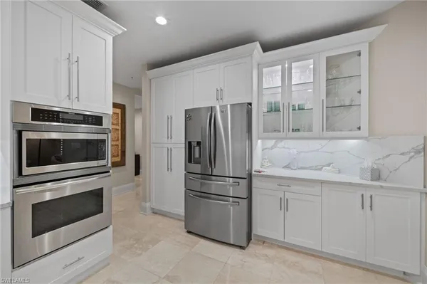 a kitchen with white cabinets and stainless steel appliances