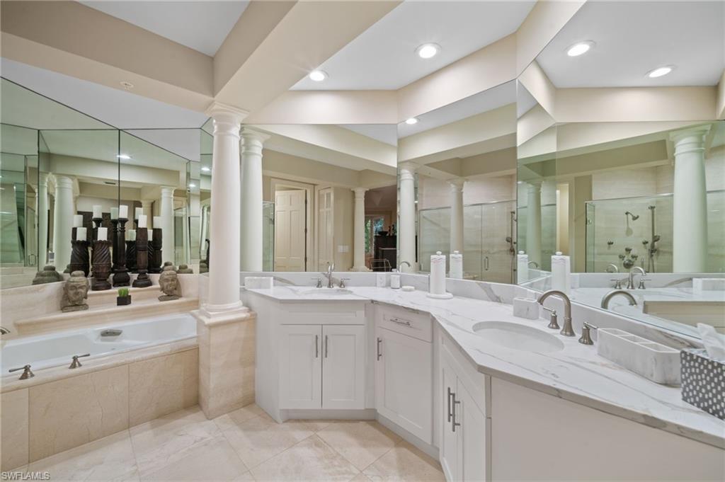 261 Colonade Circle, Unit 2701 Naples, FL 34103 - Photo 21 of 49 a large bathroom with a double vanity sink and mirror with shower