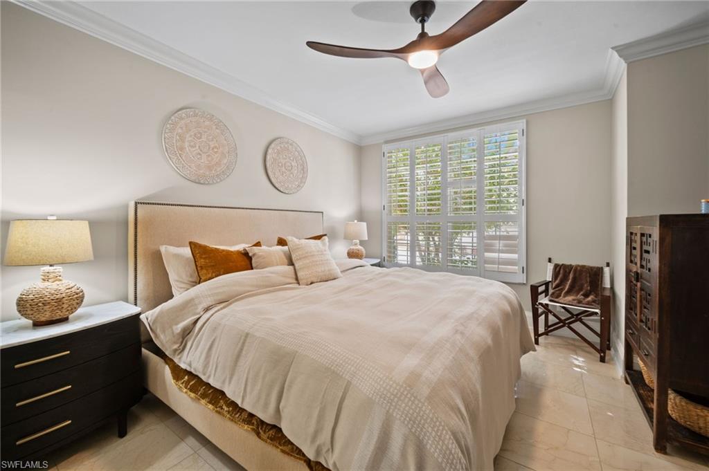 261 Colonade Circle, Unit 2701 Naples, FL 34103 - Photo 26 of 49 a bedroom with bed and a flat tv screen on dresser