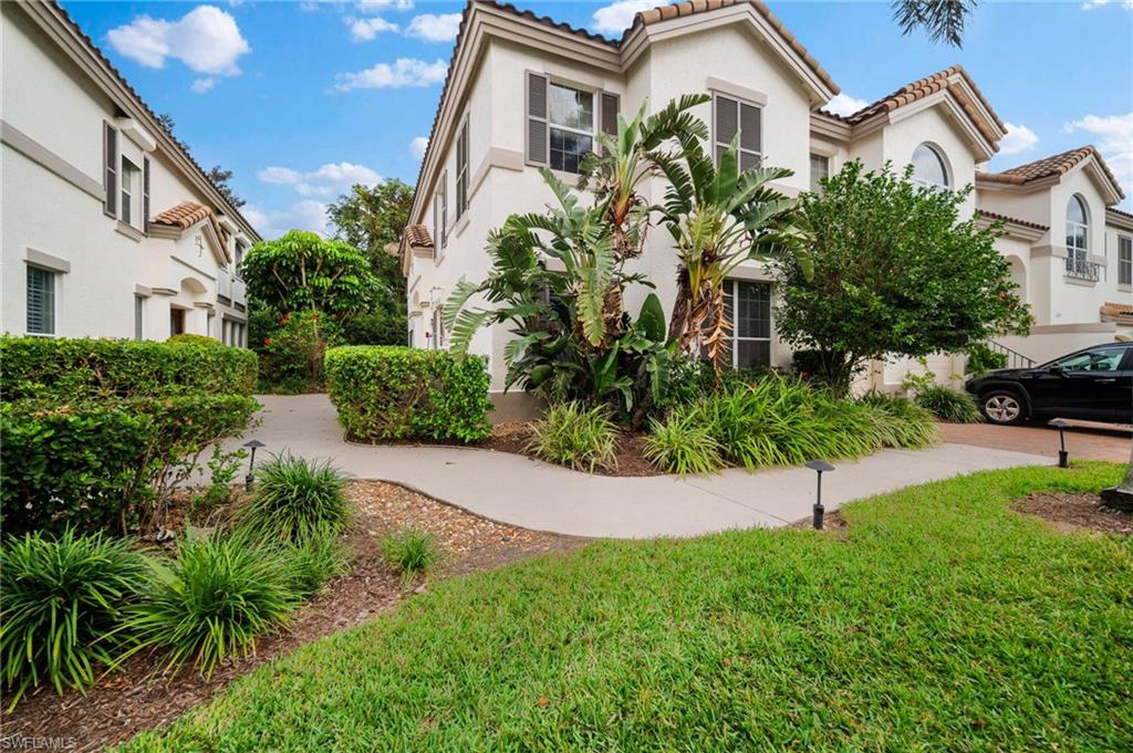 261 Colonade Circle, Unit 2701 Naples, FL 34103 - Photo 38 of 49 a front view of a house with a garden
