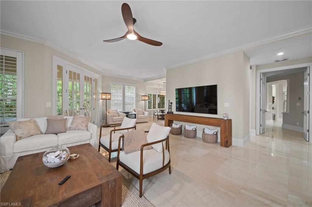 261 Colonade Circle, Unit 2701 Naples, FL 34103 - Photo 6 of 49 a living room with furniture and a flat screen tv