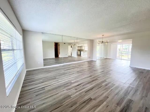 a view of a big room with wooden floor and windows
