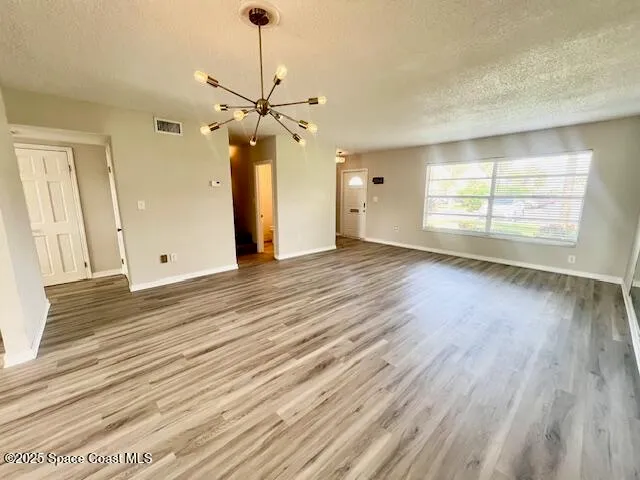 an empty room with wooden floor and outdoor view