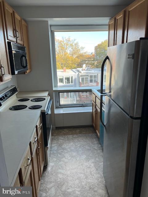 1425 4th Street Southwest, Unit A304 Washington, DC 20024 - Photo 15 of 25 a view of a kitchen with a refrigerator stove wooden floor and a window