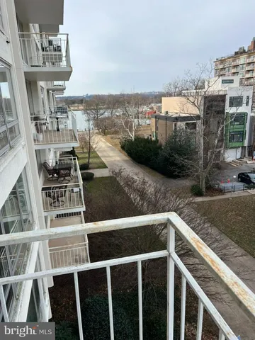 a utility room with stainless steel appliances wooden cabinet and view of living room
