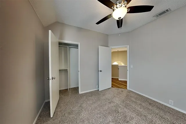 a view of an empty room and a ceiling fan