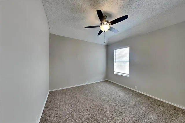 a view of a big room with a chandelier fan and windows