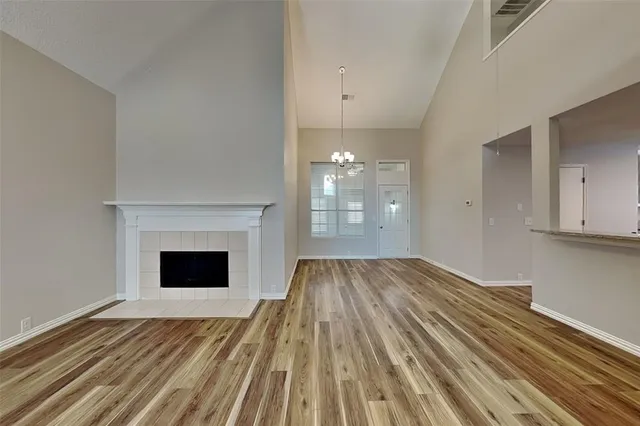 a view of empty room with wooden floor and fireplace