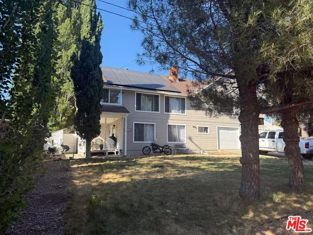 a view of a white house with a snow on the side of a road
