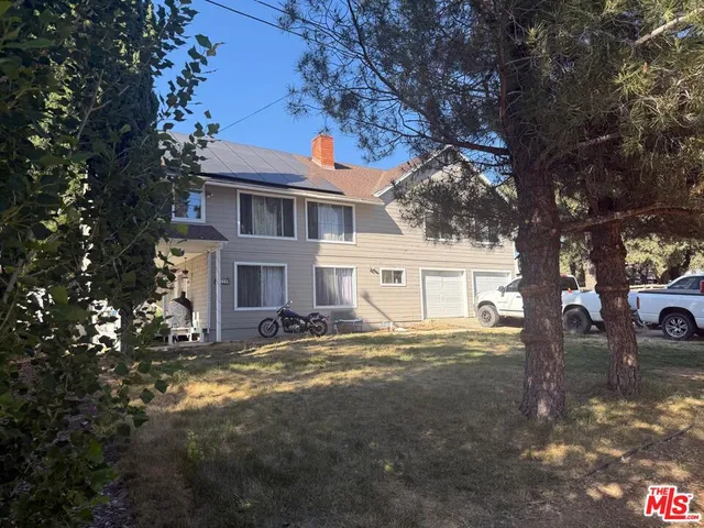 a view of a yard in front of a house with large tree