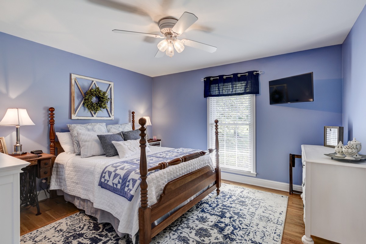 1069 Edgewater Circle Gallatin, TN 37066 - Photo 23 of 43 a bed room with a bed a couch and a chandelier