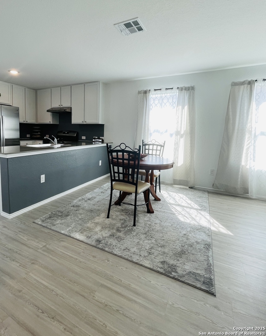 6948 Calcite Trail Elmendorf, TX 78112 - Photo 8 of 12 a kitchen with a table chairs a sink and dishwasher