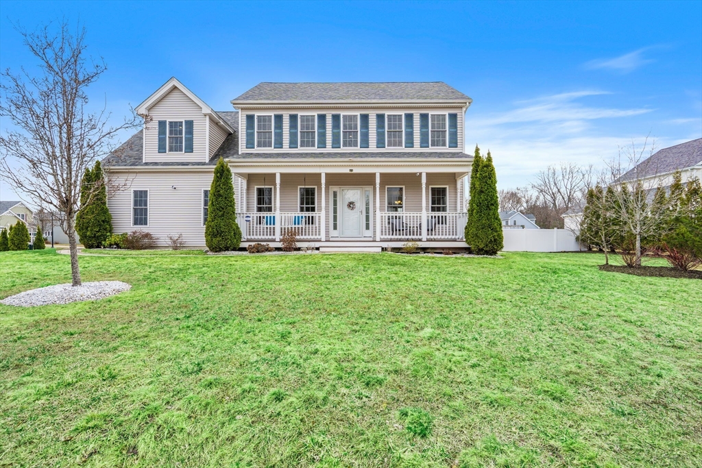 a front view of a house with a yard and trees