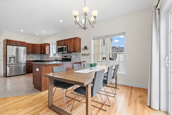 a view of a dining room with furniture a chandelier and wooden floor