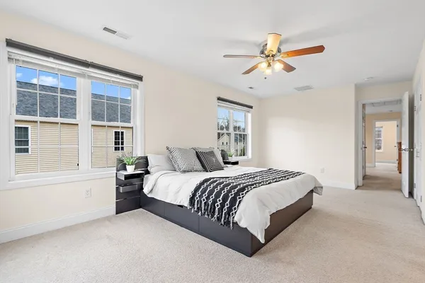 a bedroom with a bed and a ceiling fan