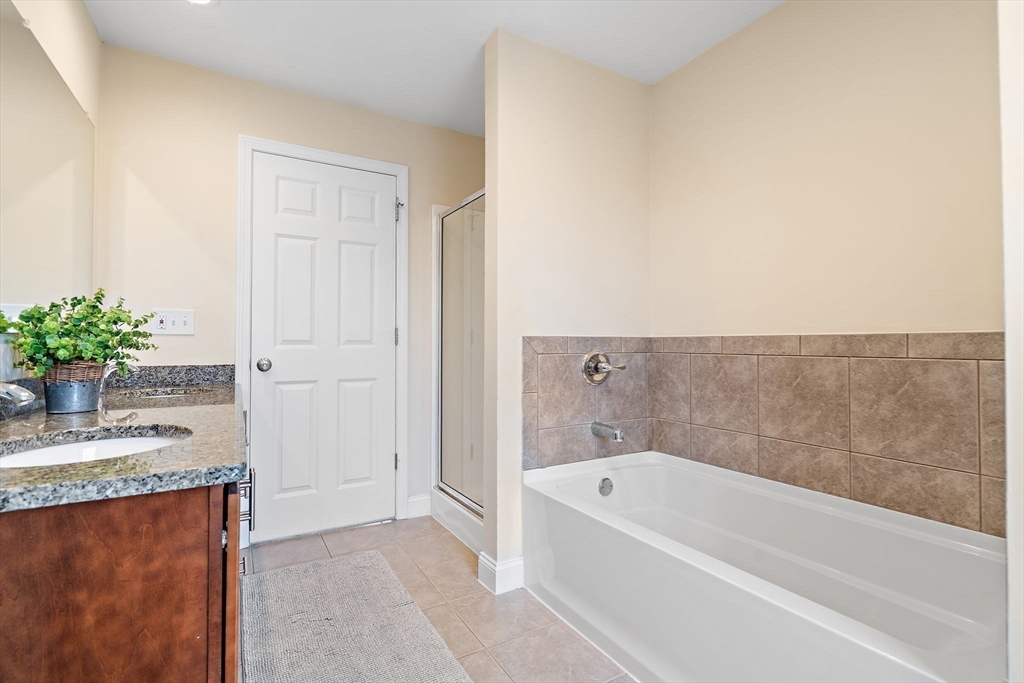 2 Northern Lights Way Bellingham, MA 02019 - Photo 23 of 40 a bathroom with a granite countertop tub a sink and a mirror