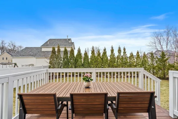 a view of a roof deck with table and chairs a barbeque with wooden floor and fence