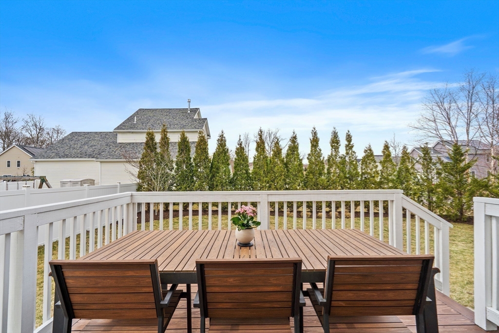 2 Northern Lights Way Bellingham, MA 02019 - Photo 9 of 40 a view of a roof deck with table and chairs a barbeque with wooden floor and fence