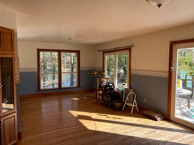 a view of a livingroom with hardwood floor and a large window