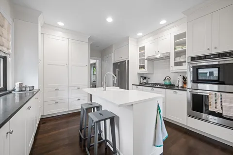 a kitchen with white cabinets and stainless steel appliances