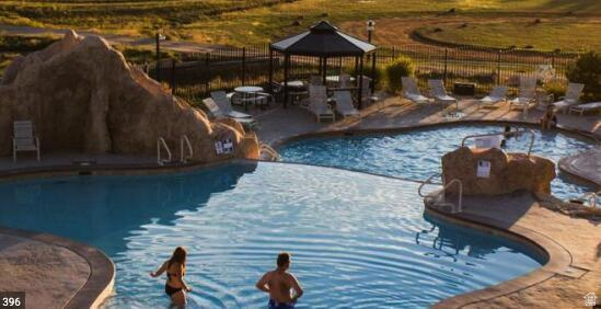 793 South Zion Road Orderville, UT 84758 - Photo 8 of 12 Resort-style aquatic area featuring multiple swimming pools, a rock-detailed grotto, an integrated spa, a shaded gazebo, and extensive lounge seating