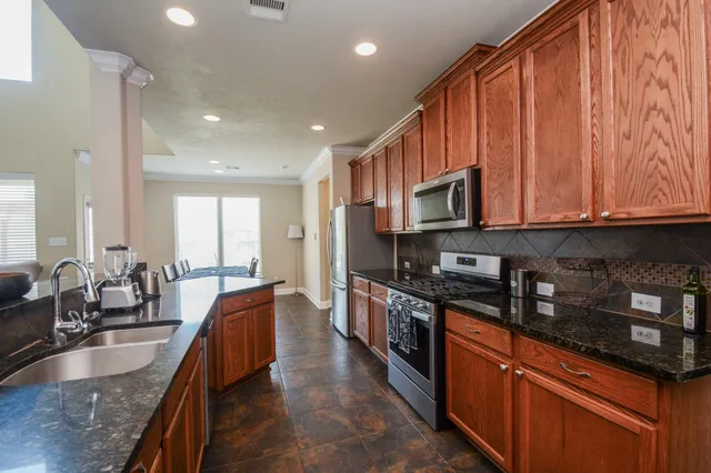 a large kitchen with stainless steel appliances granite countertop a sink stove and microwave