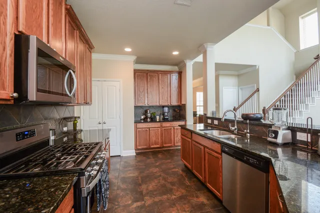 a kitchen with stainless steel appliances granite countertop a stove and a sink