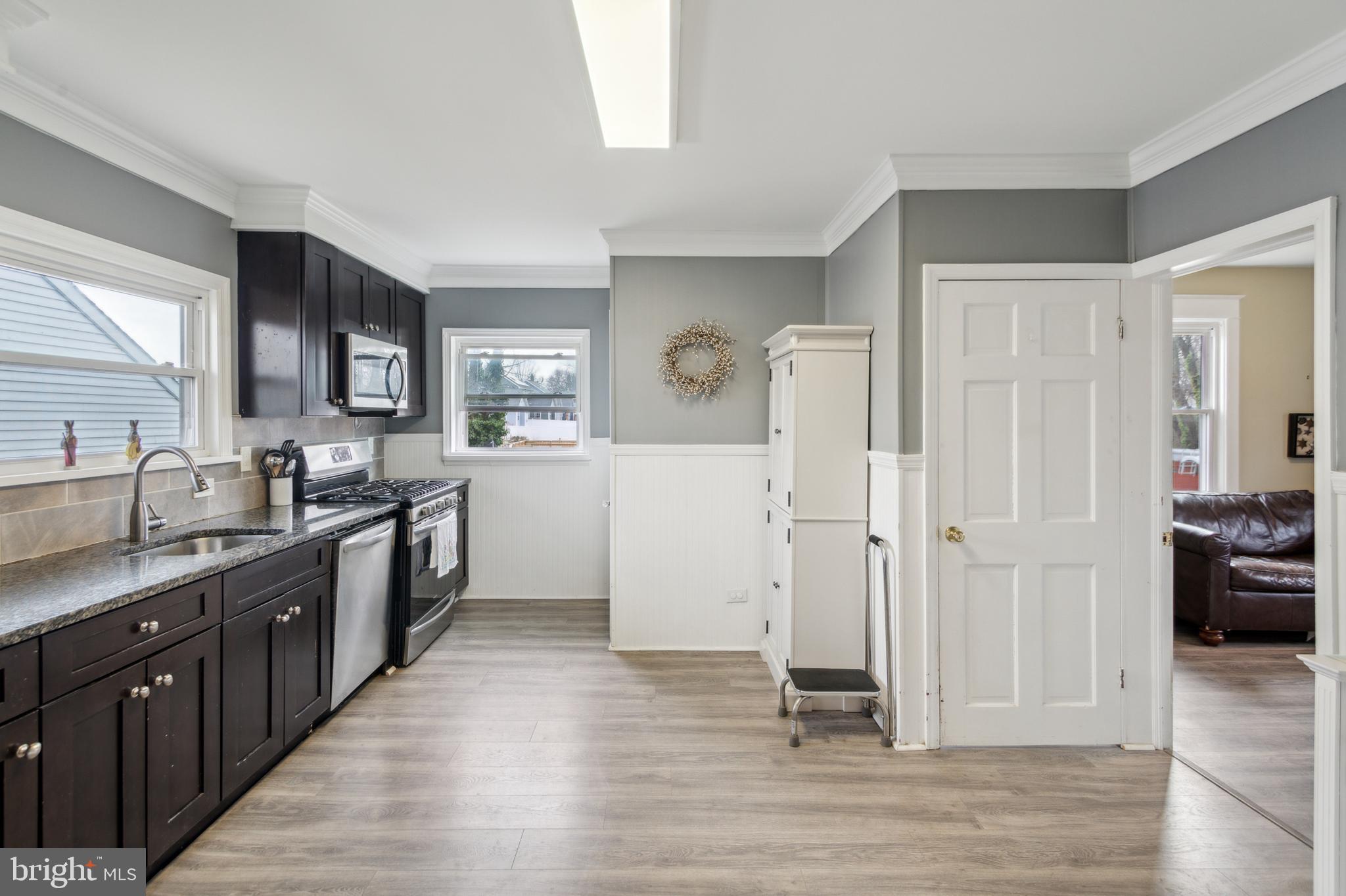 812 Lambert Avenue Mount Ephraim, NJ 08059 - Photo 8 of 24 a large kitchen with a wooden floor and a sink