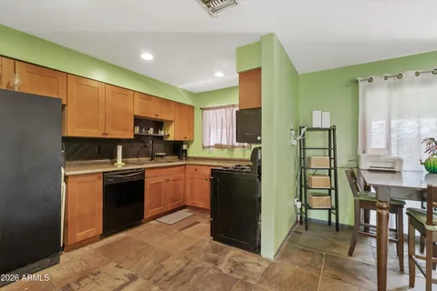 a kitchen with stainless steel appliances granite countertop a refrigerator sink and stove