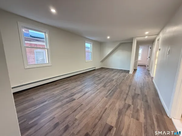 a view of empty room with wooden floor