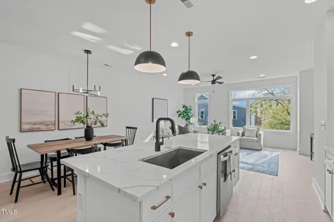 a kitchen with stainless steel appliances a table chairs and white cabinets