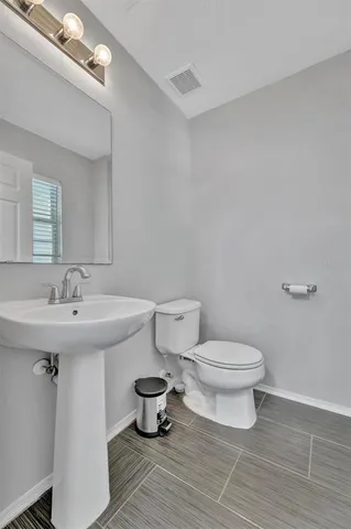 a bathroom with a sink mirror and toilet