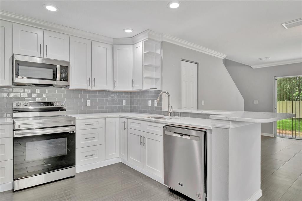 2928 Royal Tuscan Lane Valrico, FL 33594 - Photo 17 of 62 a kitchen with cabinets stainless steel appliances and wooden floor