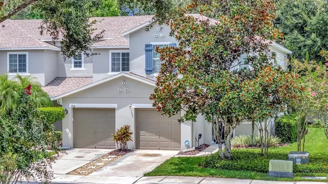 front view of a house with a yard and an trees