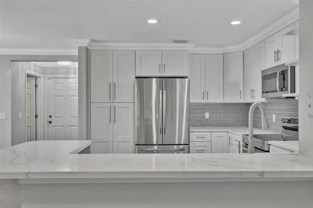 a view of a kitchen with a sink and a refrigerator