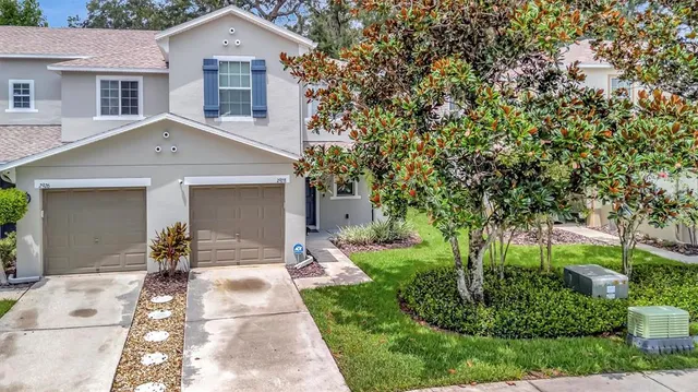 a front view of a house with a yard and potted plants