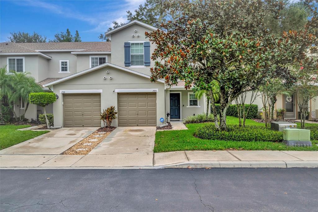 2928 Royal Tuscan Lane Valrico, FL 33594 - Photo 5 of 62 a front view of a house with a garden and trees