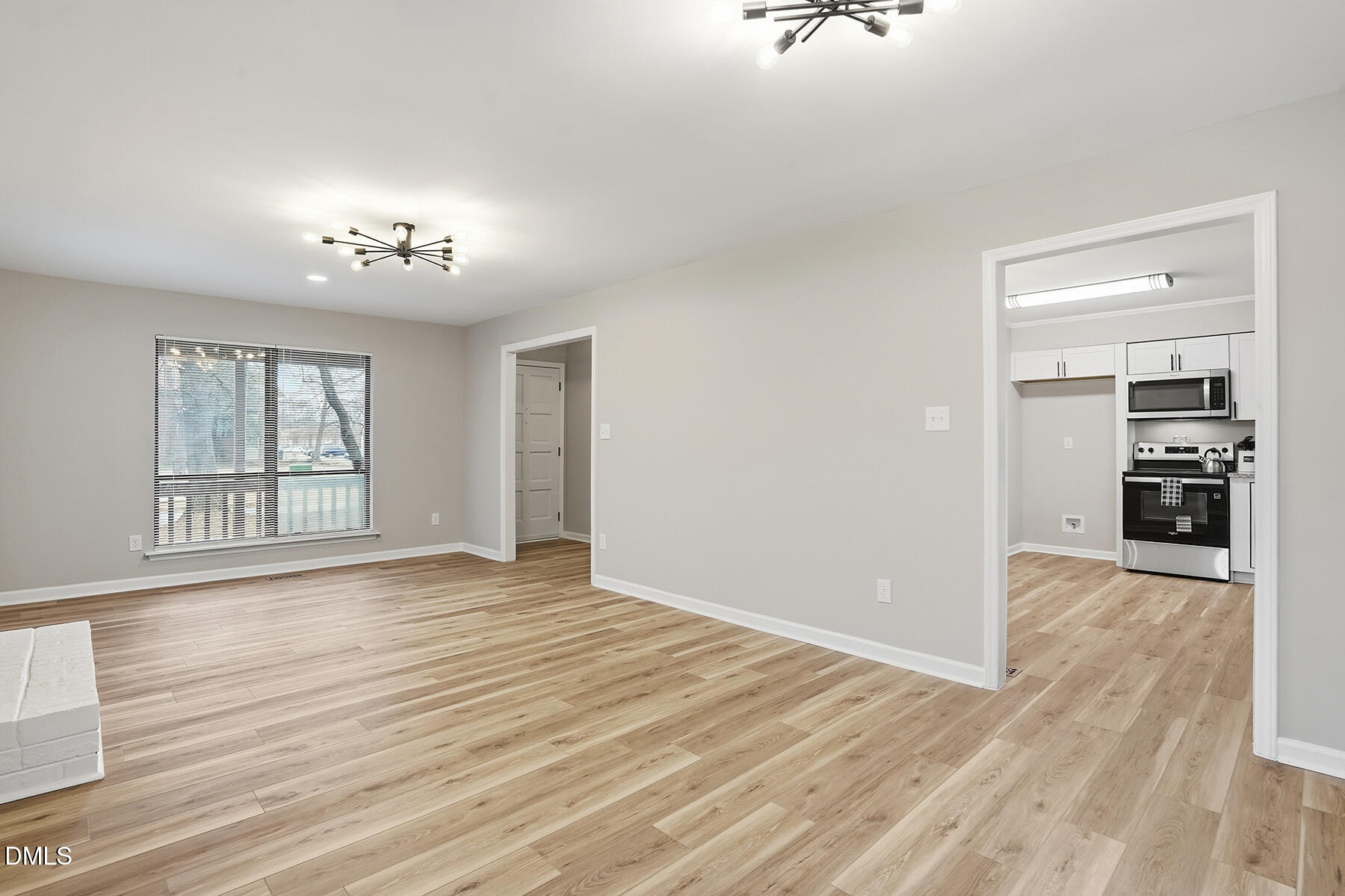 812 Chalk Level Road Durham, NC 27704 - Photo 6 of 31 a view of an empty room with a window and wooden floor