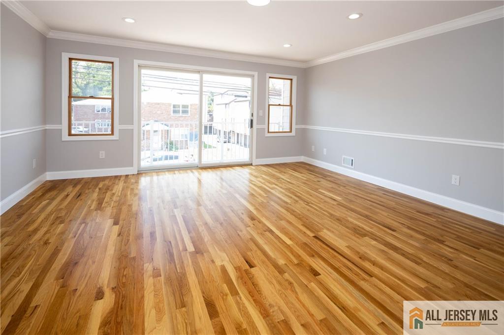 278 Rector Street Perth Amboy, NJ 08861 - Photo 15 of 47 an empty room with wooden floor and windows
